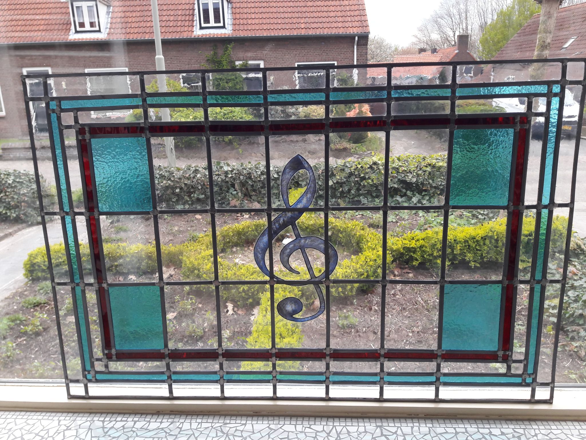 Gebrandschilderde muzieknoot verwerkt in voorzet raam
